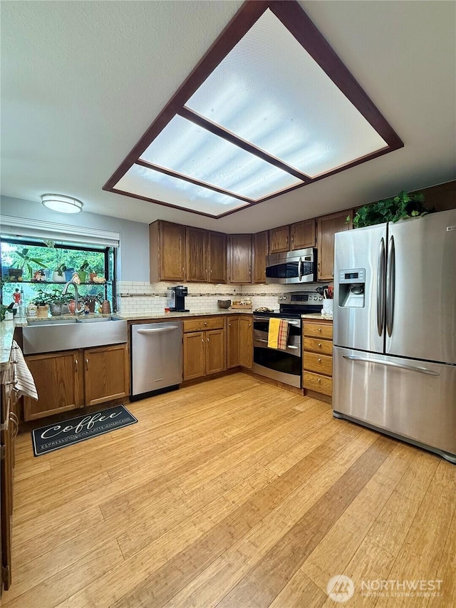 21849 SE 266th Pl, Maple Valley, WA 98038 - kitchen with stainless steel appliances, light wood-style floors, a sink, and light countertops