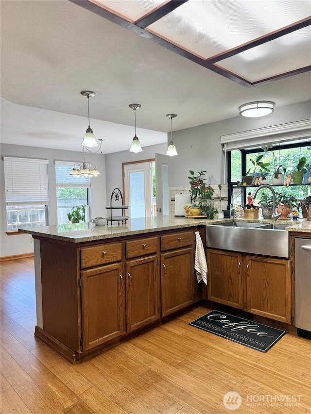 21849 SE 266th Pl, Maple Valley, WA 98038 - kitchen with light wood-style flooring, dishwasher, a sink, and brown cabinets