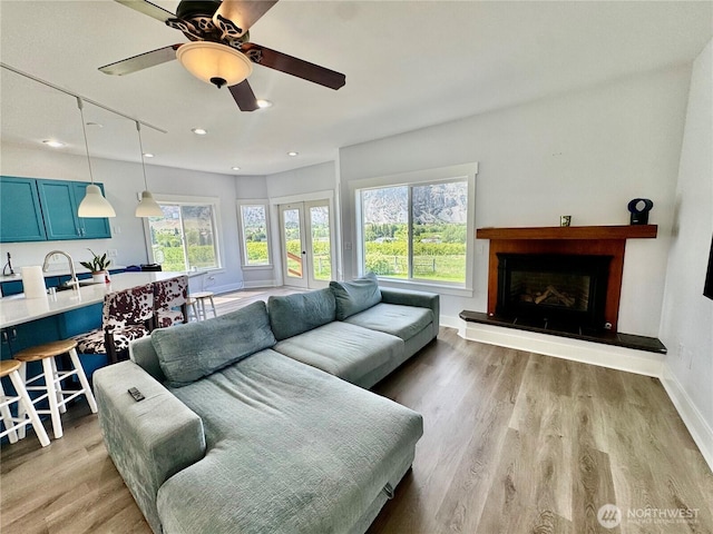 31 Apple Meadow Dr, Tonasket, WA 98855 - living room featuring baseboards, light wood-type flooring, a ceiling fan, a fireplace with raised hearth, and recessed lighting