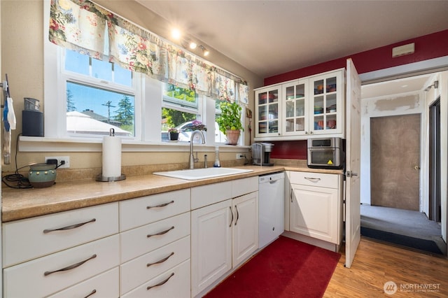 214 N 4th St, Mount Vernon, WA 98273 - kitchen featuring dishwasher, a sink, glass insert cabinets, white cabinetry, and light wood-type flooring