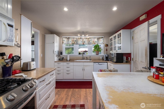 214 N 4th St, Mount Vernon, WA 98273 - kitchen featuring white appliances, a sink, white cabinetry, dark wood finished floors, and recessed lighting