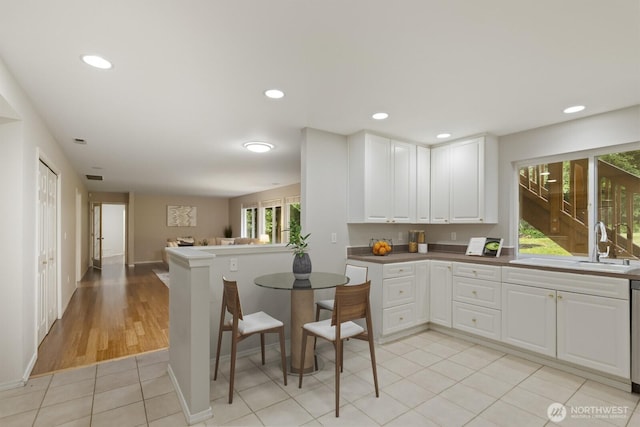 820 173rd Ave NE, Bellevue, WA 98008 - kitchen featuring white cabinetry, baseboards, open floor plan, a sink, and recessed lighting
