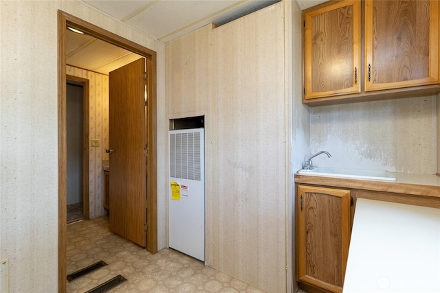545 NE Troutdale Ave, College Place, WA 99324 - kitchen featuring a heating unit, light flooring, light countertops, a sink, and brown cabinetry