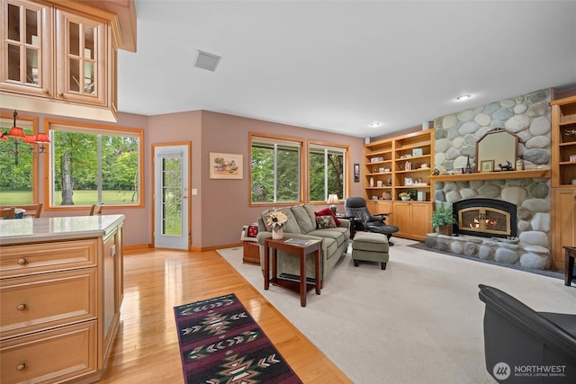 5426 Quail Run, Blaine, WA 98230 - living room featuring healthy amount of natural light, a stone fireplace, and light wood-type flooring