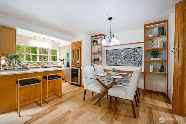 5430 Snow Goose Ln Unit 202, Blaine, WA 98230 - dining room featuring beverage cooler, a chandelier, light wood-style floors, and track lighting