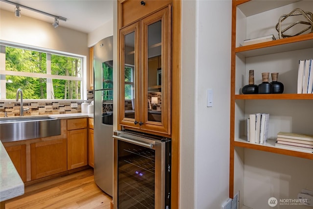 5430 Snow Goose Ln Unit 202, Blaine, WA 98230 - bar with beverage cooler, a sink, light wood-style floors, track lighting, and tasteful backsplash