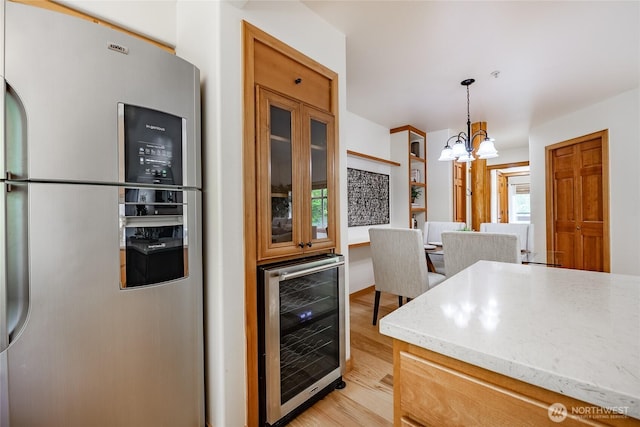 5430 Snow Goose Ln Unit 202, Blaine, WA 98230 - kitchen featuring stainless steel fridge, wine cooler, light wood-style flooring, a chandelier, and light stone countertops
