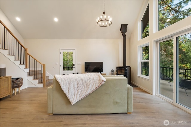 living area with stairs, light wood-style floors, a chandelier, recessed lighting, and a high ceiling