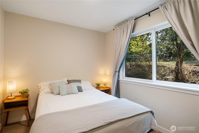 bedroom with baseboards and wood finished floors