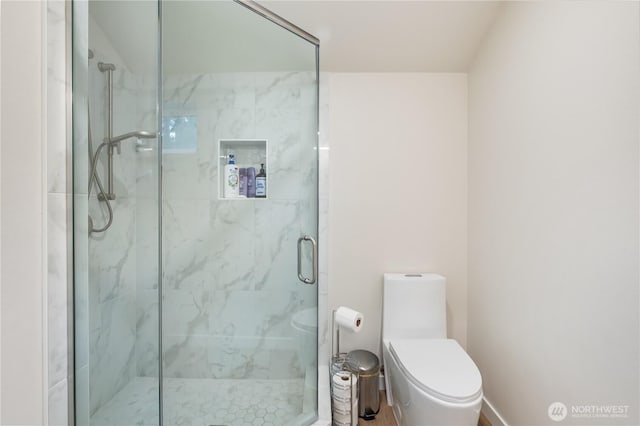 bathroom with a marble finish shower and toilet