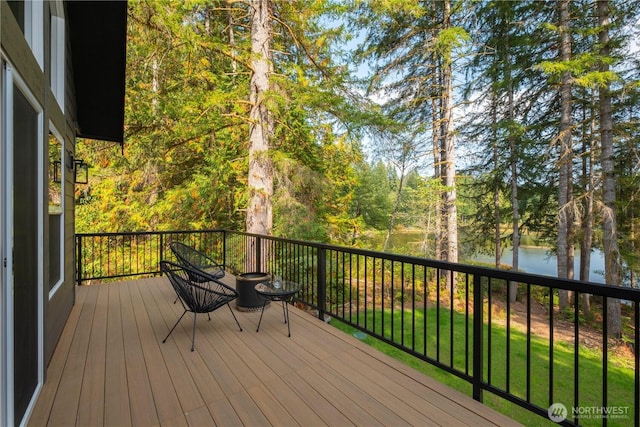 deck with a water view and view of scattered trees