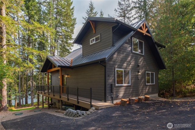 view of side of property featuring a deck and metal roof