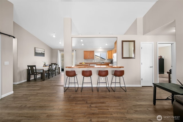 1348 Wheatridge Dr, East Wenatchee, WA 98802 - kitchen with freestanding refrigerator, a barn door, high vaulted ceiling, recessed lighting, and a peninsula
