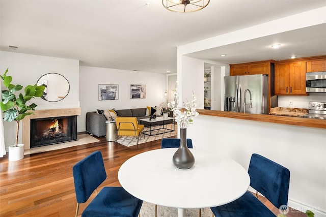 16929 Inglewood Rd NE Unit C206, Kenmore, WA 98028 - dining room featuring wood finished floors, a multi sided fireplace, and recessed lighting