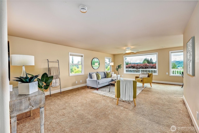 carpeted living room with healthy amount of natural light, ceiling fan, and baseboards