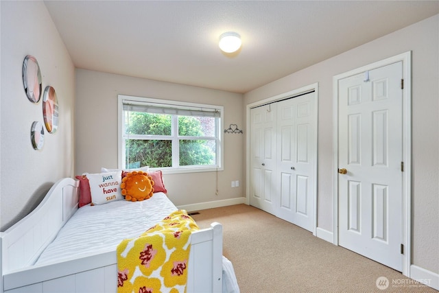 bedroom with carpet flooring, baseboards, and a closet
