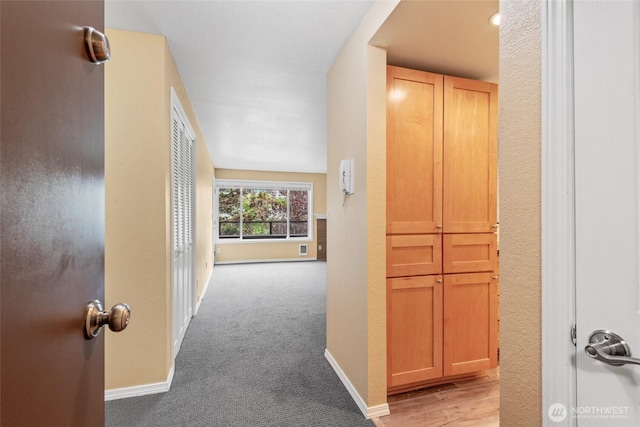 6055 35th Ave SW Unit 207, Seattle, WA 98126 - hallway with baseboards and light carpet