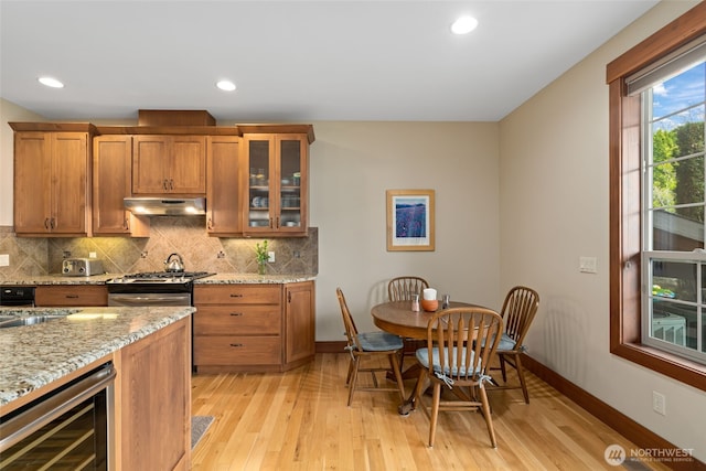 1051 N Baker Unit B104, East Wenatchee, WA 98802 - kitchen featuring beverage cooler, under cabinet range hood, brown cabinetry, light wood-type flooring, and recessed lighting