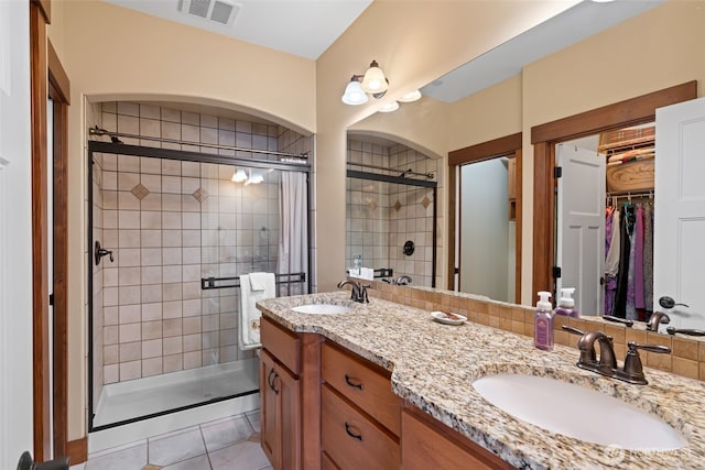 1051 N Baker Unit B104, East Wenatchee, WA 98802 - bathroom with a stall shower, double vanity, a walk in closet, and tile patterned floors