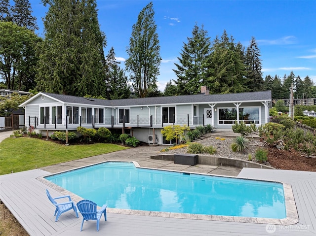 7415 Stinson Ave, Gig Harbor, WA 98335 - back of property with an outdoor pool, a chimney, a lawn, and a wooden deck