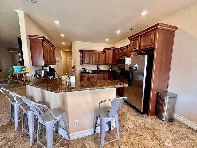 523 N Paxson Dr, Moses Lake, WA 98837 - kitchen featuring stainless steel appliances, a peninsula, a kitchen breakfast bar, baseboards, and recessed lighting