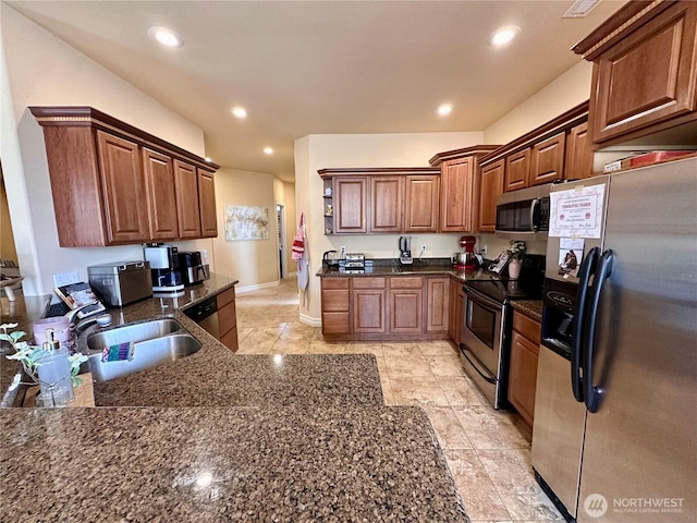 523 N Paxson Dr, Moses Lake, WA 98837 - kitchen with stainless steel appliances, a sink, recessed lighting, baseboards, and dark stone countertops