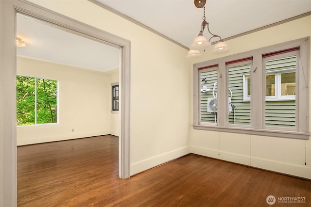 spare room with baseboards, wood finished floors, and ornamental molding