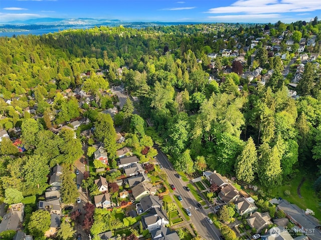view of property location featuring a heavily wooded area and nearby suburban area