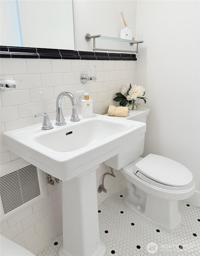 1105 Spring St Unit 904, Seattle, WA 98104 - bathroom featuring toilet, tile walls, and tile patterned flooring
