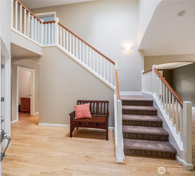 5215 E Lake Bosworth Dr, Snohomish, WA 98290 - stairway featuring wood finished floors, arched walkways, a high ceiling, and baseboards