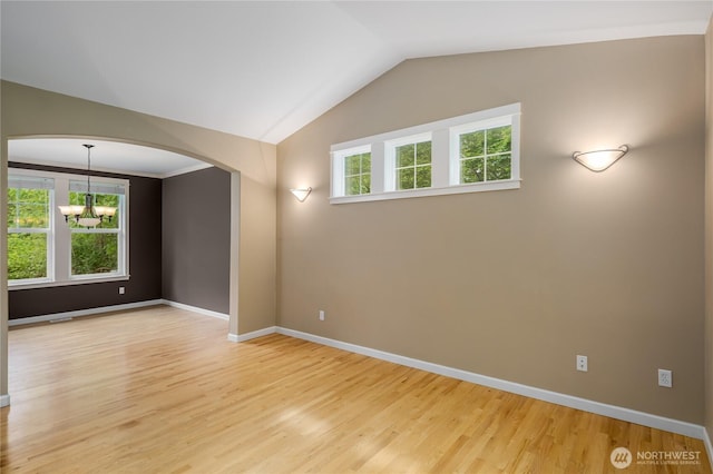 5215 E Lake Bosworth Dr, Snohomish, WA 98290 - spare room with light wood-style flooring, a chandelier, baseboards, vaulted ceiling, and arched walkways