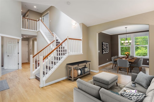 5215 E Lake Bosworth Dr, Snohomish, WA 98290 - living area featuring arched walkways, stairs, baseboards, wood finished floors, and a chandelier