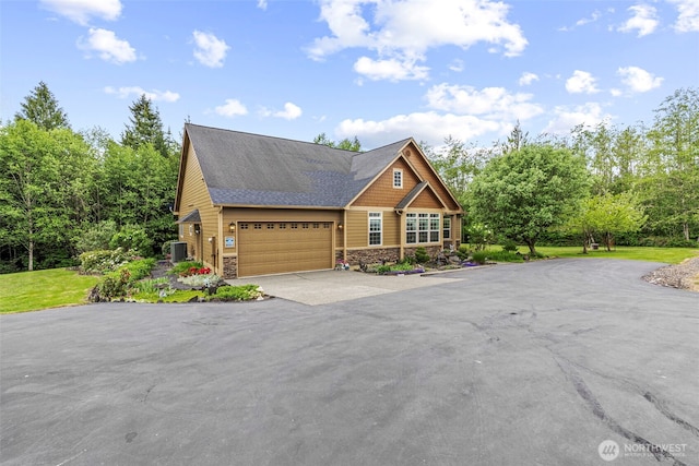 108 Reynolds Rd, Castle Rock, WA 98611 - view of front facade with asphalt driveway, stone siding, roof with shingles, cooling unit, and an attached garage