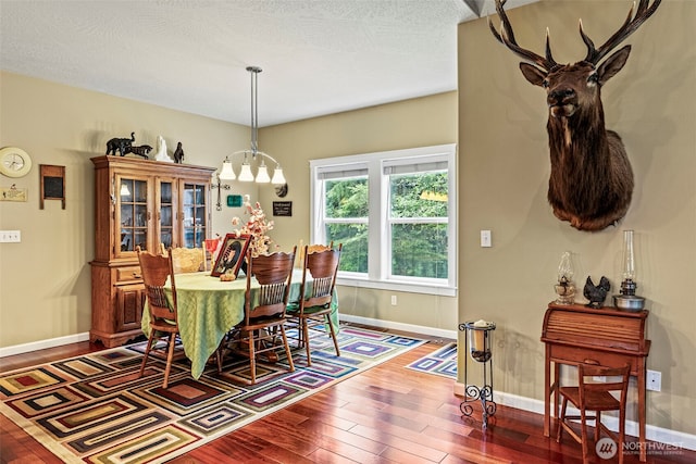 108 Reynolds Rd, Castle Rock, WA 98611 - dining area with hardwood / wood-style floors, baseboards, and a chandelier