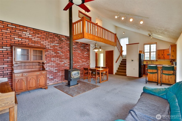 257 Point Brown Ave SW, Ocean Shores, WA 98569 - living room with light carpet, stairs, a ceiling fan, a textured ceiling, and a wood stove