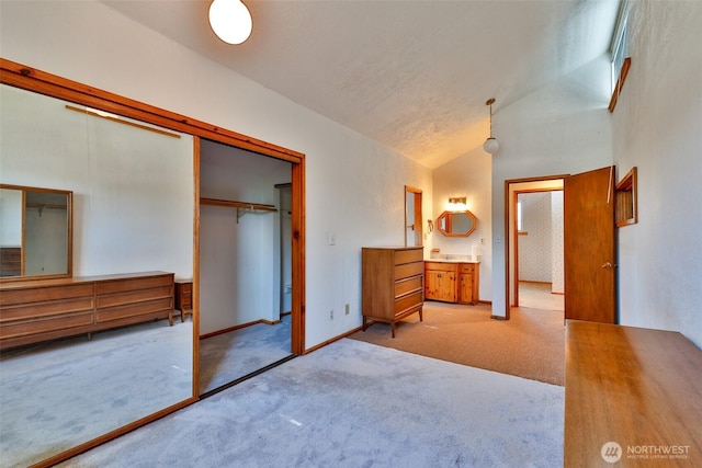 257 Point Brown Ave SW, Ocean Shores, WA 98569 - bedroom with light colored carpet, a closet, lofted ceiling, baseboards, and ensuite bath