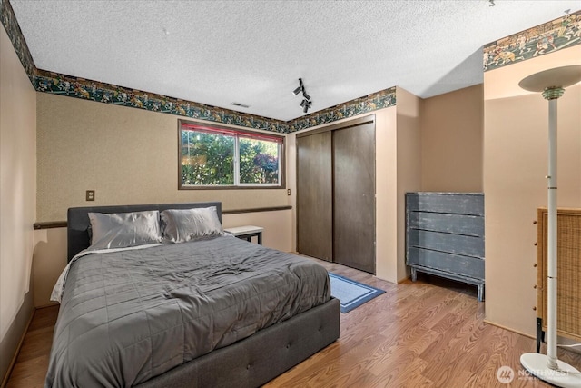 17631 69th Pl W, Edmonds, WA 98026 - bedroom featuring wood finished floors, a textured ceiling, track lighting, and a closet