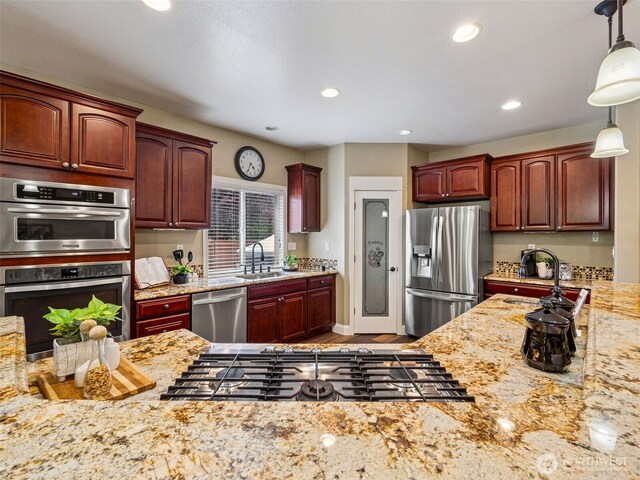20714 61st St E, Bonney Lake, WA 98391 - kitchen with appliances with stainless steel finishes, a sink, decorative light fixtures, recessed lighting, and light stone counters