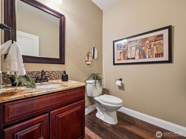 20714 61st St E, Bonney Lake, WA 98391 - bathroom featuring baseboards, wood finished floors, vanity, toilet, and tasteful backsplash