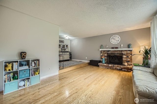 8918 108th St SW, Lakewood, WA 98498 - living room with a textured ceiling, wood finished floors, baseboards, and a fireplace