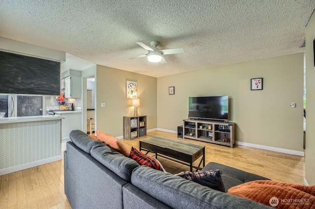 8918 108th St SW, Lakewood, WA 98498 - living area with ceiling fan, light wood-style flooring, baseboards, and a textured ceiling