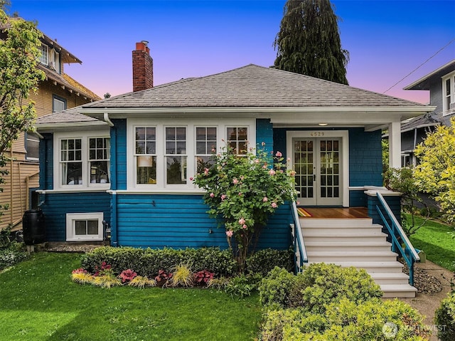 4529 Eastern Ave N, Seattle, WA 98103 - view of front of home featuring french doors, a chimney, a front yard, and stairs