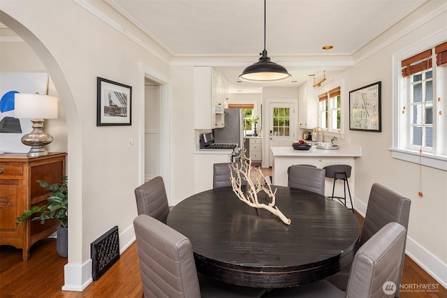 4529 Eastern Ave N, Seattle, WA 98103 - dining space with arched walkways, wood finished floors, baseboards, and crown molding