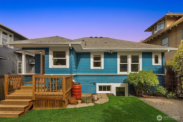 4529 Eastern Ave N, Seattle, WA 98103 - back of house at dusk with a lawn, a shingled roof, and a wooden deck