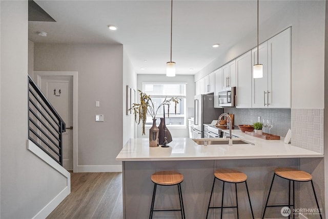 825 238th Pl SE Unit D, Bothell, WA 98021 - kitchen with appliances with stainless steel finishes, baseboards, light wood-style flooring, decorative backsplash, and white cabinetry