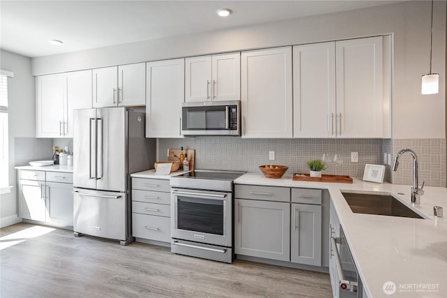 825 238th Pl SE Unit D, Bothell, WA 98021 - kitchen featuring appliances with stainless steel finishes, a sink, light countertops, backsplash, and light wood-style floors