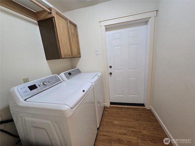 laundry area featuring cabinet space, separate washer and dryer, dark wood finished floors, and baseboards