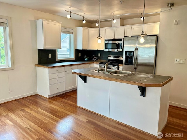 13426 97th Ave E Unit 301, Puyallup, WA 98373 - kitchen with stainless steel appliances, tile countertops, a sink, and white cabinetry