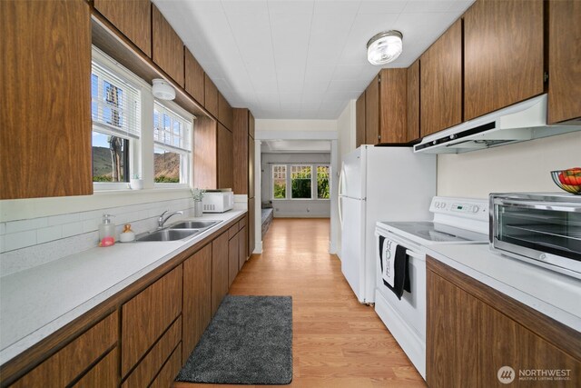 21500 US-97, Orondo, WA 98843 - kitchen with white appliances, under cabinet range hood, a sink, tasteful backsplash, and light countertops