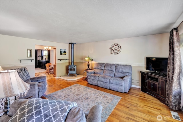 10208 28th Ave SW, Seattle, WA 98146 - living room featuring a wood stove, light wood-style floors, and baseboards